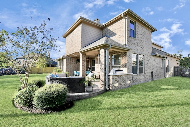 rear view of house with a yard, an outdoor kitchen, an outdoor living space, and a patio