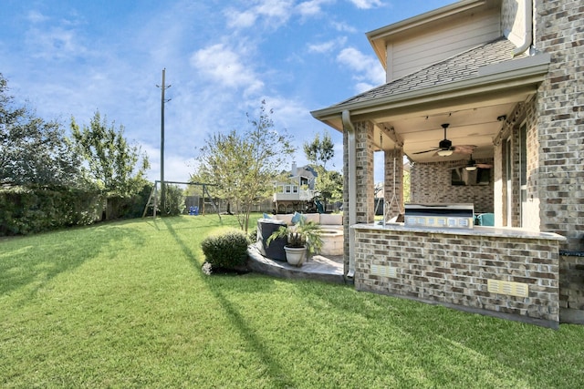 view of yard featuring ceiling fan, a patio, and exterior kitchen