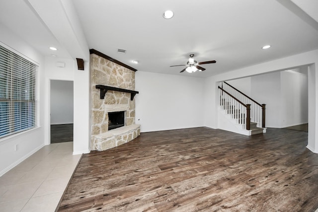 unfurnished living room with a fireplace and ceiling fan