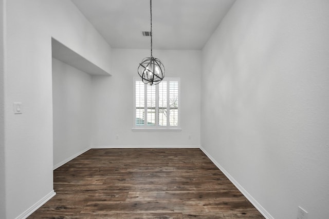 unfurnished dining area with an inviting chandelier and dark hardwood / wood-style floors