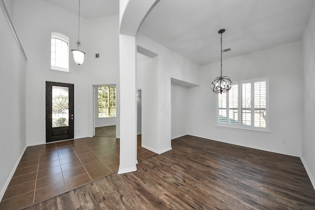 entryway featuring a notable chandelier, a high ceiling, and dark wood-type flooring