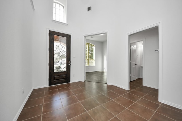 tiled foyer entrance featuring a towering ceiling