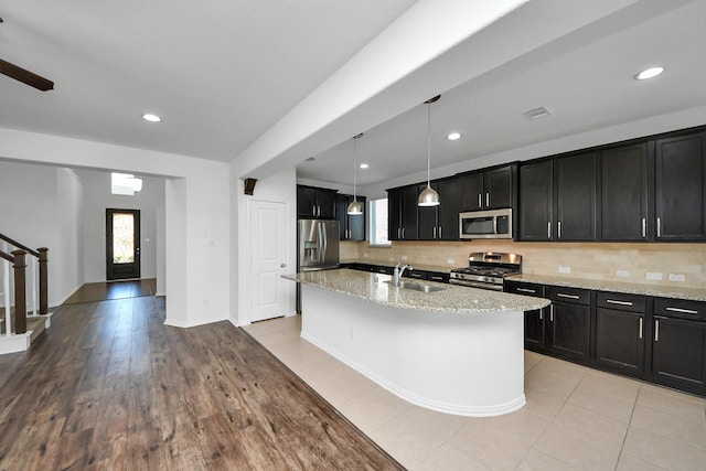 kitchen featuring decorative light fixtures, sink, decorative backsplash, and stainless steel appliances