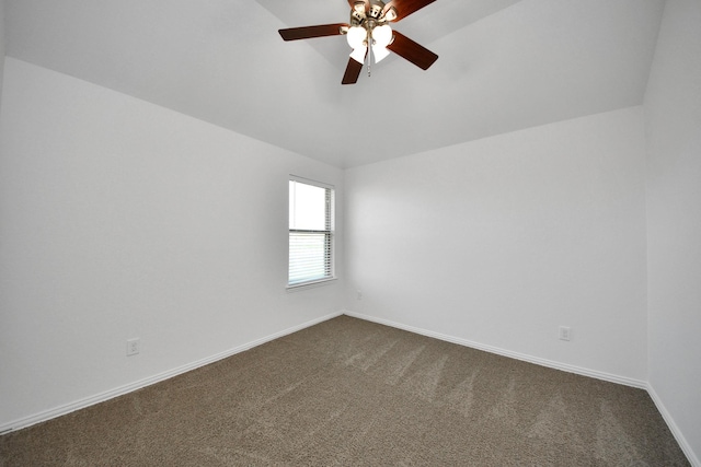 spare room featuring ceiling fan and dark carpet