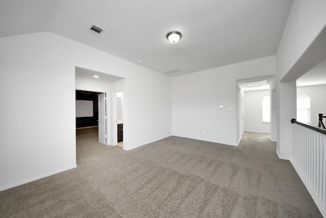 unfurnished room with vaulted ceiling and carpet