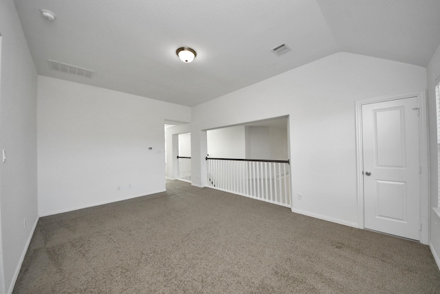 carpeted spare room featuring vaulted ceiling