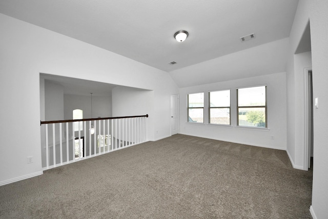 spare room with carpet flooring and vaulted ceiling