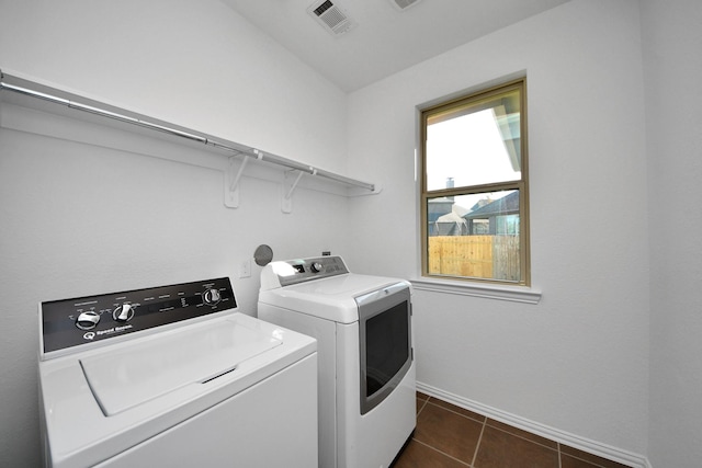 laundry room with separate washer and dryer and dark tile patterned floors