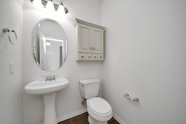 bathroom with toilet and tile patterned flooring