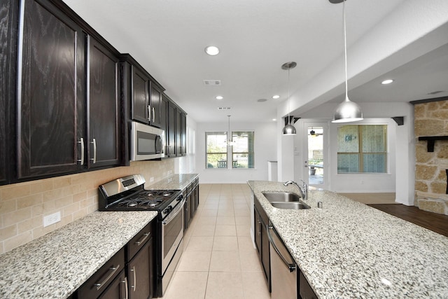 kitchen with sink, decorative light fixtures, appliances with stainless steel finishes, and backsplash