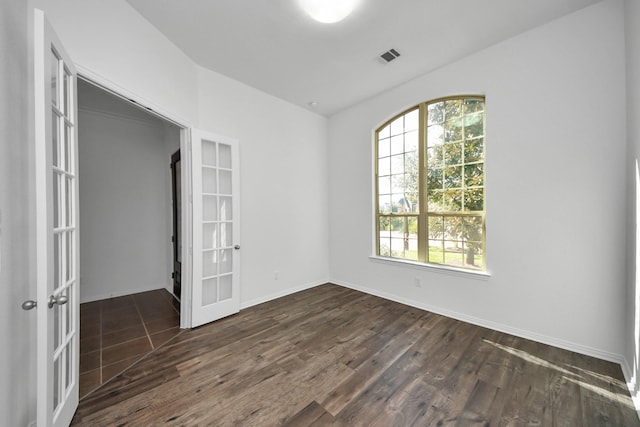 empty room with dark hardwood / wood-style flooring and french doors