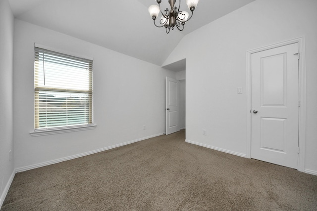 spare room featuring carpet, lofted ceiling, and an inviting chandelier