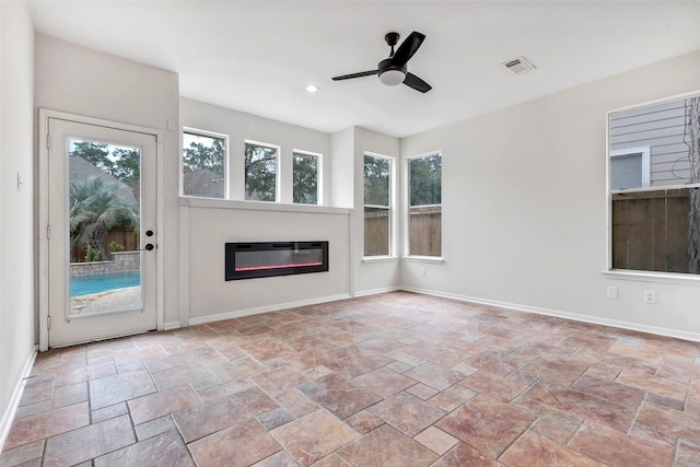 unfurnished living room featuring ceiling fan and heating unit