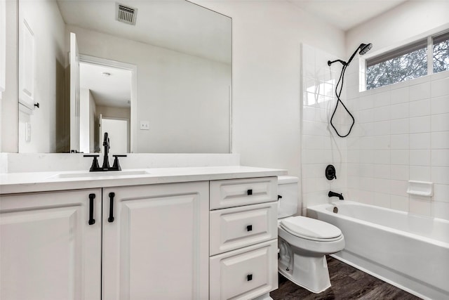 full bathroom featuring vanity, hardwood / wood-style floors, toilet, and tiled shower / bath