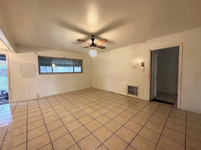 empty room featuring ceiling fan, heating unit, and light tile patterned flooring