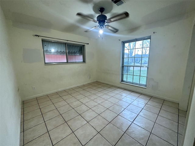 tiled spare room featuring ceiling fan