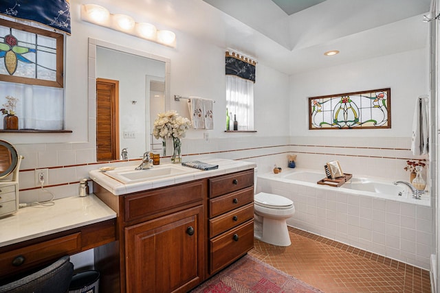 bathroom featuring tiled bath, tile patterned floors, vanity, and toilet