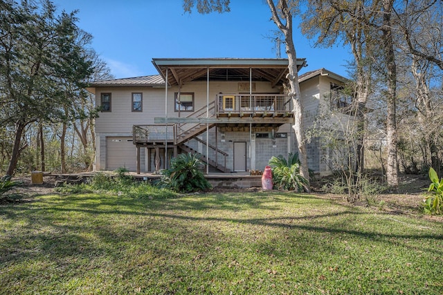 back of house with a garage, a lawn, and a balcony