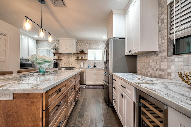 kitchen with white cabinets, light stone countertops, beverage cooler, and dark hardwood / wood-style floors