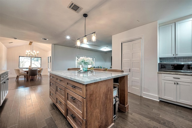 kitchen with white cabinetry, hanging light fixtures, and a kitchen island