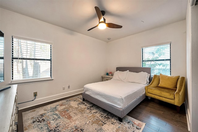 bedroom with ceiling fan, dark wood-type flooring, and multiple windows