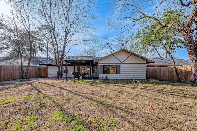 rear view of property featuring a yard and a patio