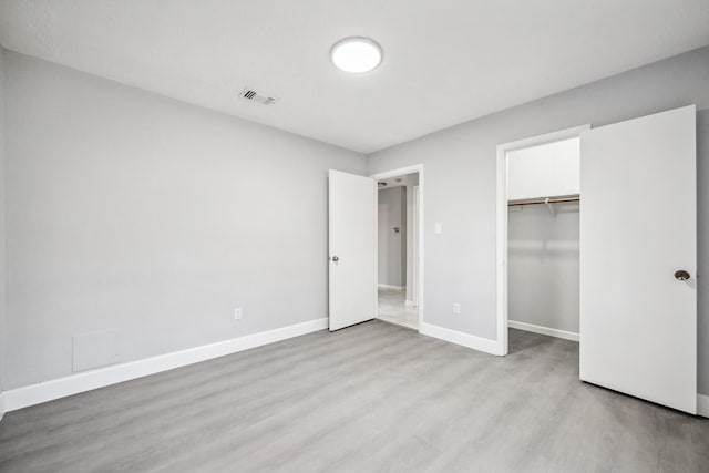 unfurnished bedroom featuring a closet and light hardwood / wood-style floors