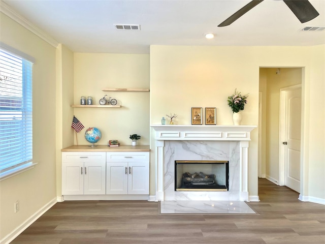 unfurnished living room with a healthy amount of sunlight, visible vents, and a premium fireplace