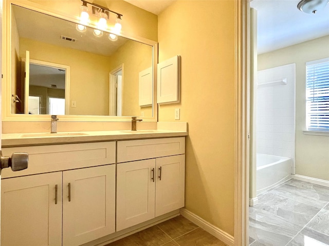 full bathroom featuring visible vents, a sink, baseboards, and double vanity