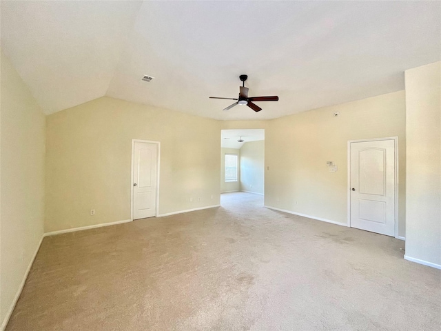 carpeted spare room with lofted ceiling, ceiling fan, and baseboards