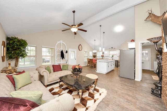 living room with ceiling fan, sink, and high vaulted ceiling