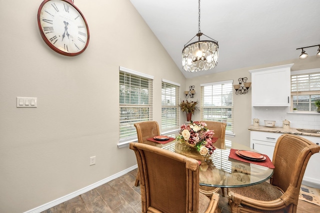 dining area featuring hardwood / wood-style floors, a chandelier, and vaulted ceiling