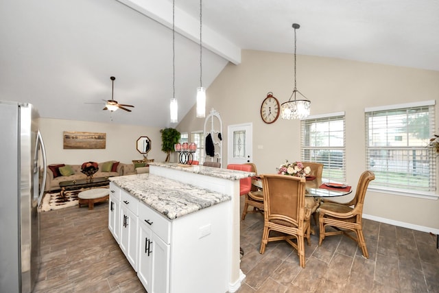 kitchen featuring a center island, pendant lighting, light stone countertops, white cabinets, and stainless steel fridge