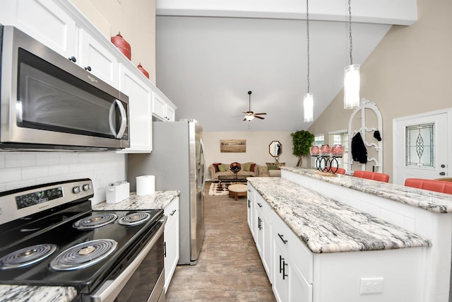 kitchen featuring lofted ceiling, white cabinets, decorative backsplash, and stainless steel appliances