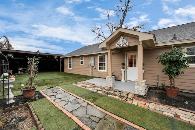 rear view of property featuring a patio area and a yard