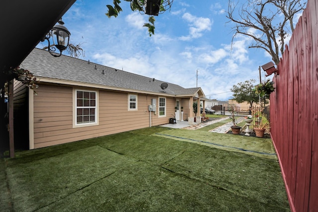 rear view of property with a lawn and a patio