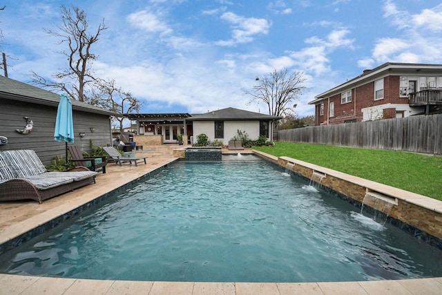 view of pool featuring pool water feature, a patio area, an in ground hot tub, and a yard