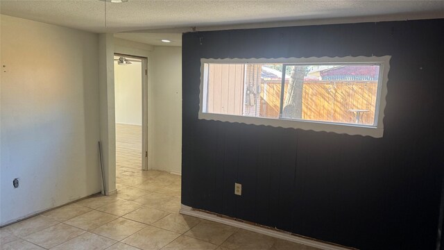 tiled spare room with a textured ceiling