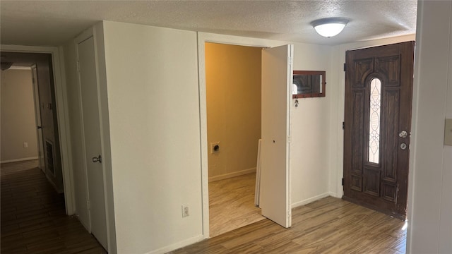 entrance foyer with a textured ceiling and light hardwood / wood-style flooring