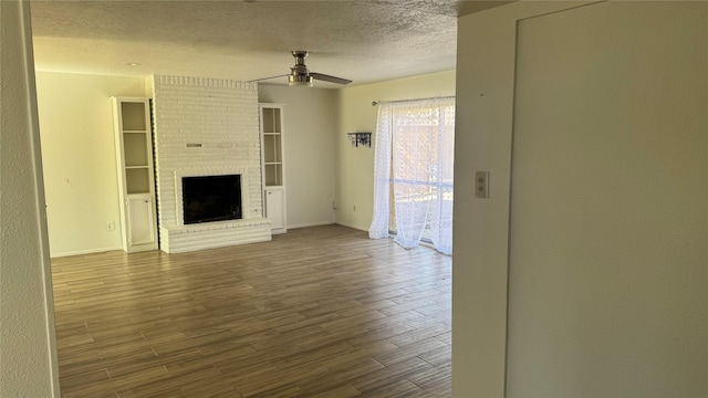 unfurnished living room featuring a fireplace, a textured ceiling, and ceiling fan