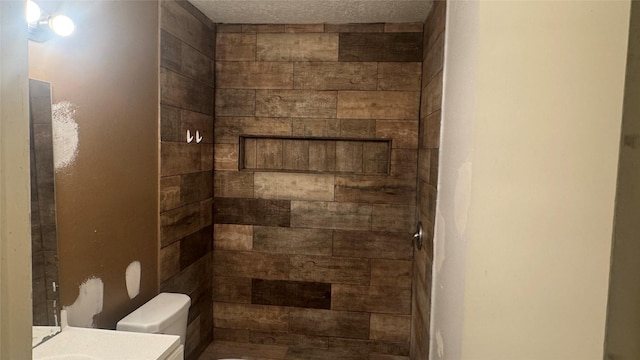 bathroom with vanity, toilet, and a textured ceiling