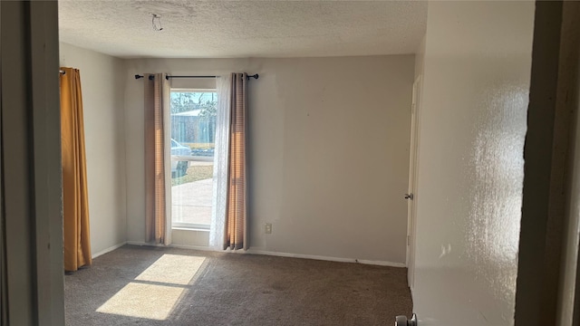 empty room featuring dark carpet and a textured ceiling