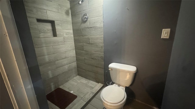 bathroom featuring toilet and tiled shower