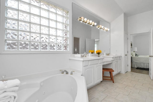 bathroom featuring tiled bath, tile patterned floors, and vanity