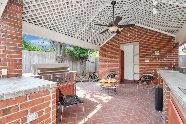 view of patio with ceiling fan, an outdoor kitchen, and grilling area