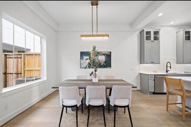 dining area with light wood-type flooring, plenty of natural light, and sink