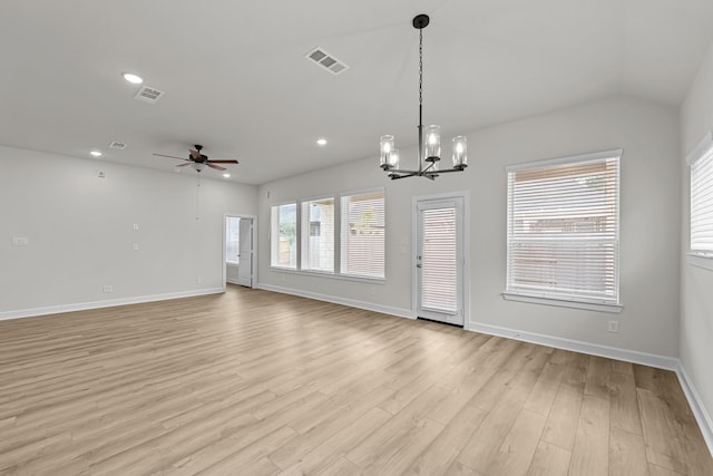 empty room featuring ceiling fan with notable chandelier, lofted ceiling, and light hardwood / wood-style floors