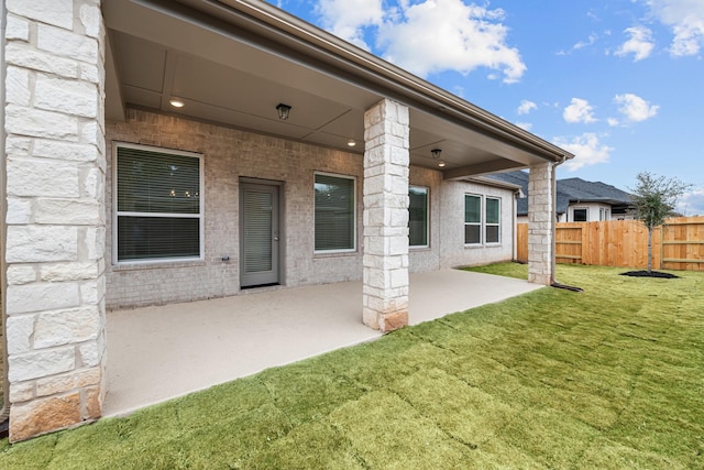 back of house with a lawn and a patio area