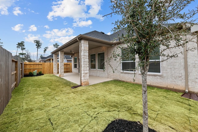 rear view of house with a patio and a lawn