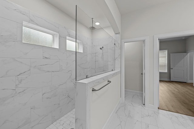 bathroom featuring tiled shower and plenty of natural light